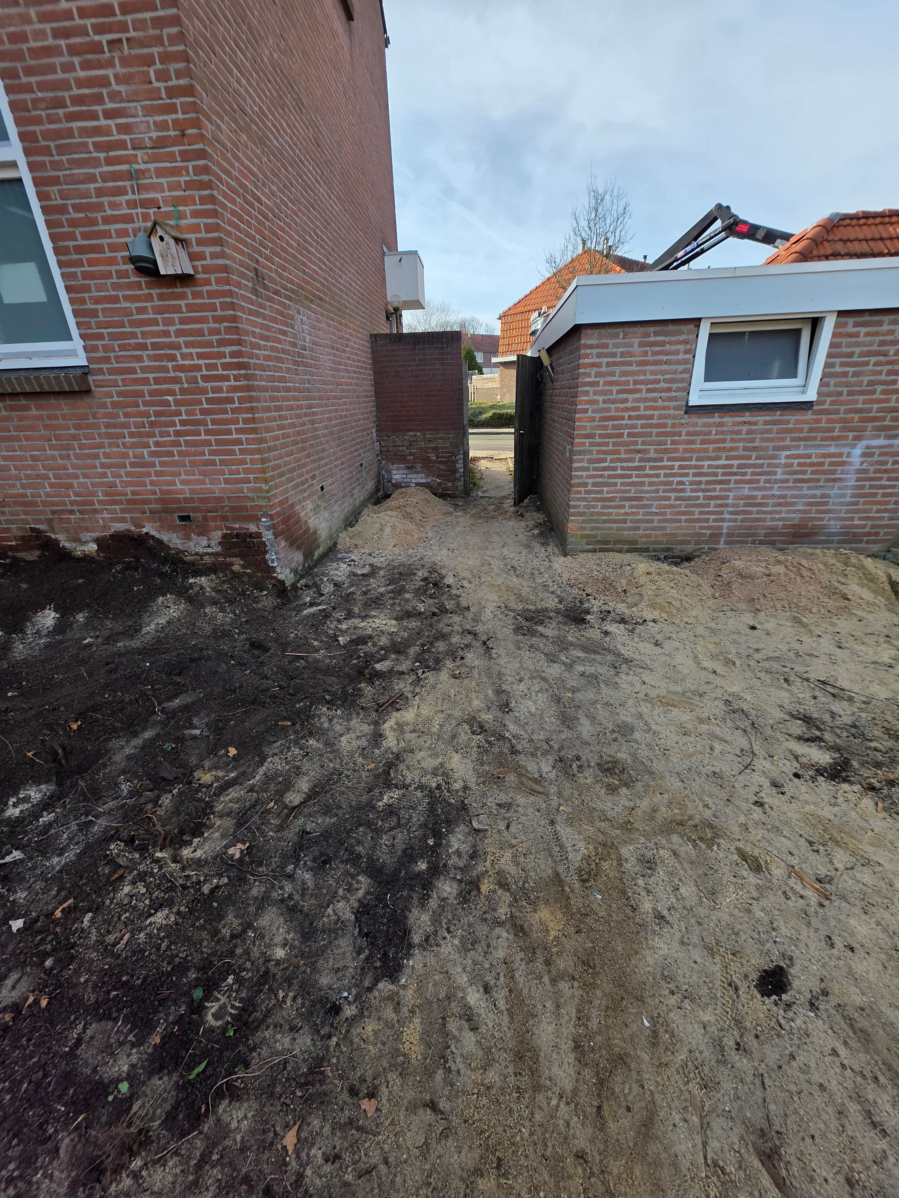 Bouwplaats tussen twee bakstenen huizen
