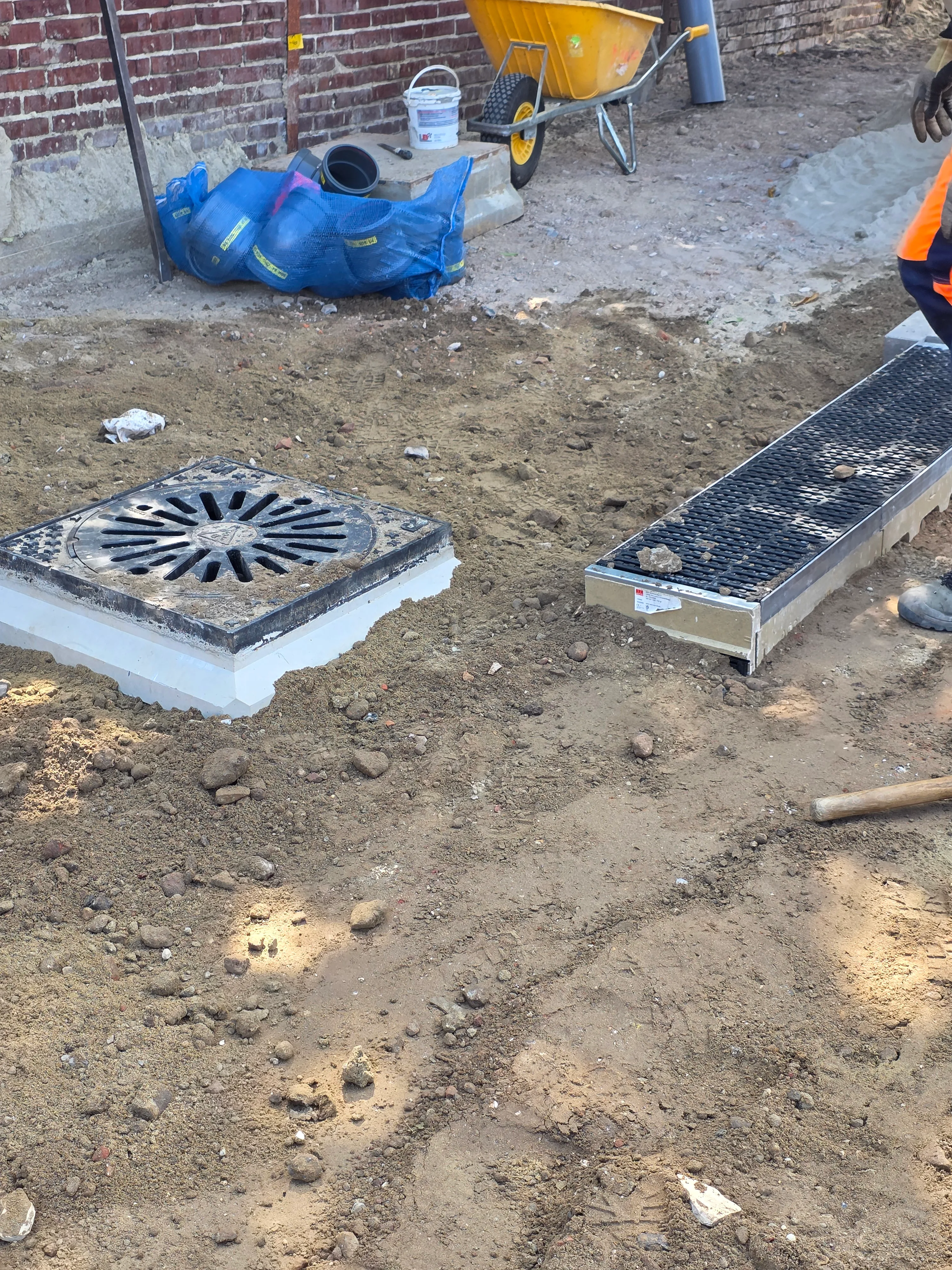 Grondwerk en drainage: uitgegraven grond met afwateringssysteem op de bouwplaats