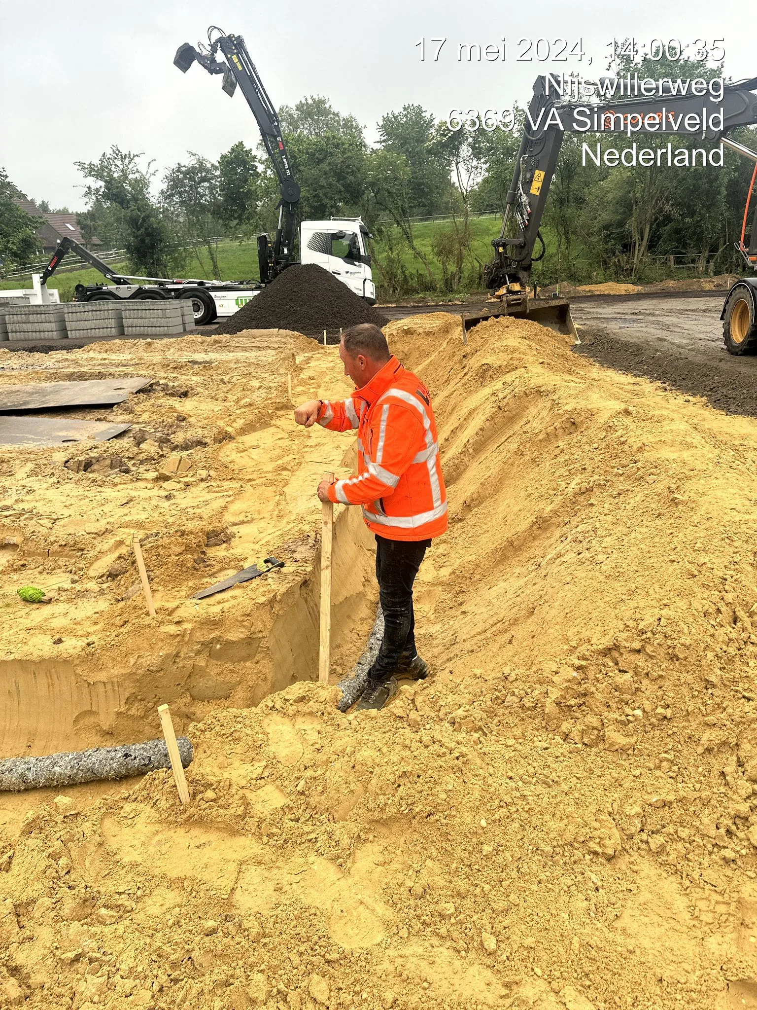 Grondwerk: arbeider inspecteert zandgronduitgraving bij bouwwerkzaamheden