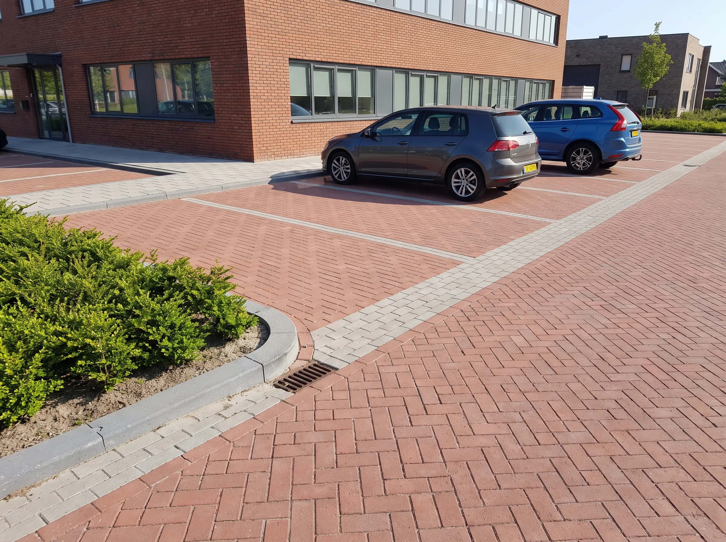 Parkeerterrein met rode klinkerklinkers, opsluitbanden en drainage