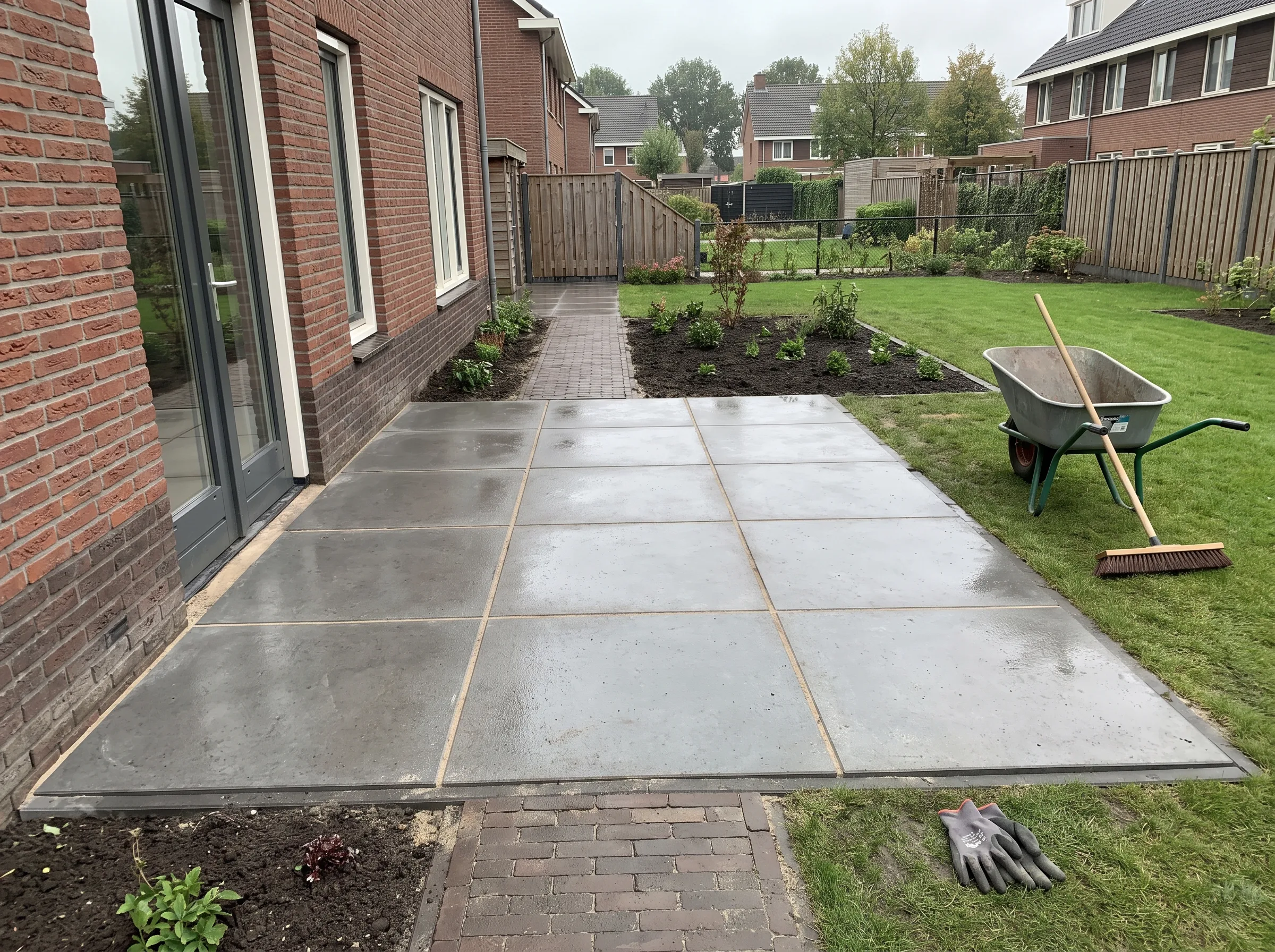Terrasbestrating aangelegd met grote betonnen tegels met voegen