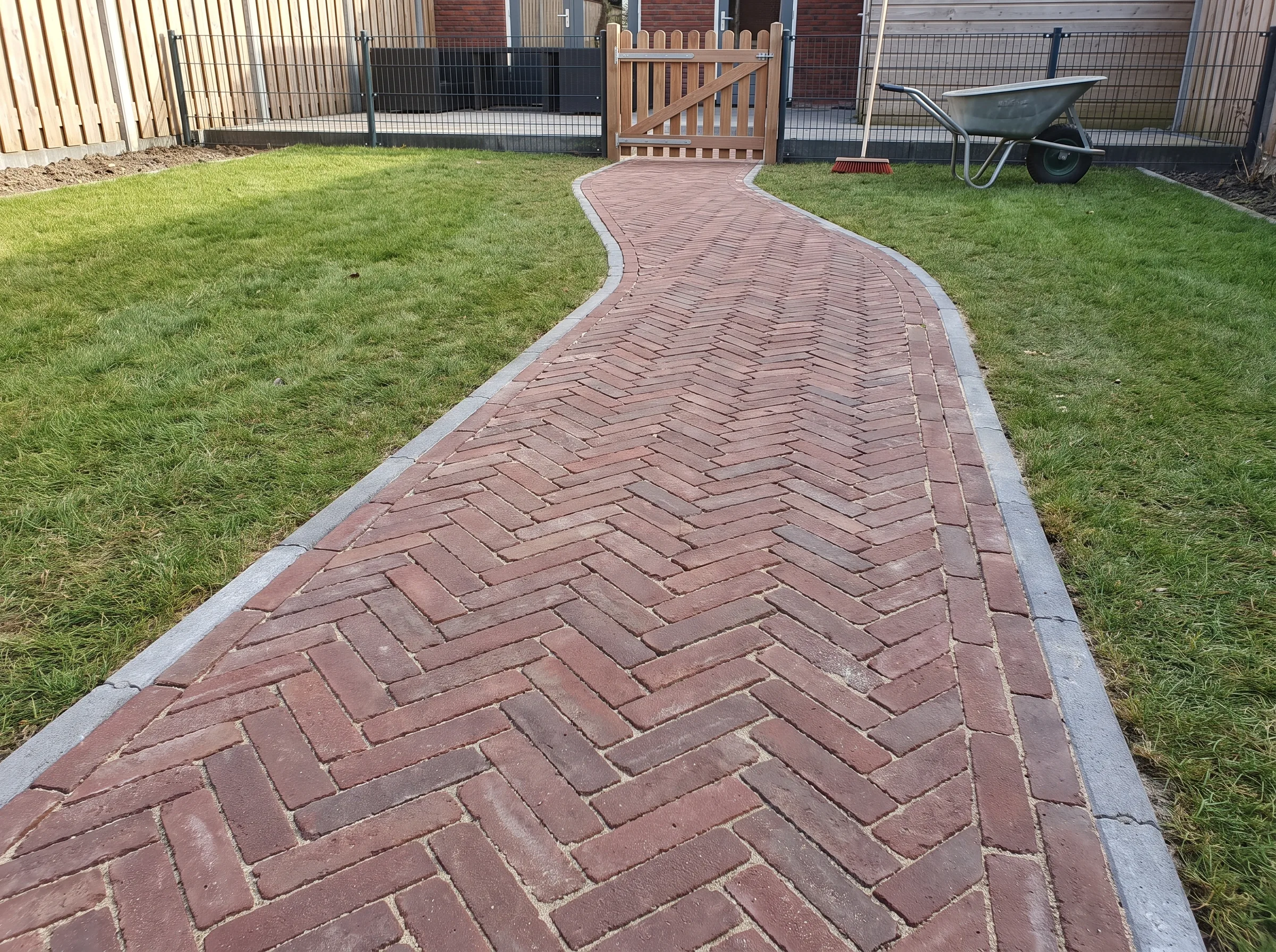 Bruin klinkerpad in herringbone patroon met witte voegen