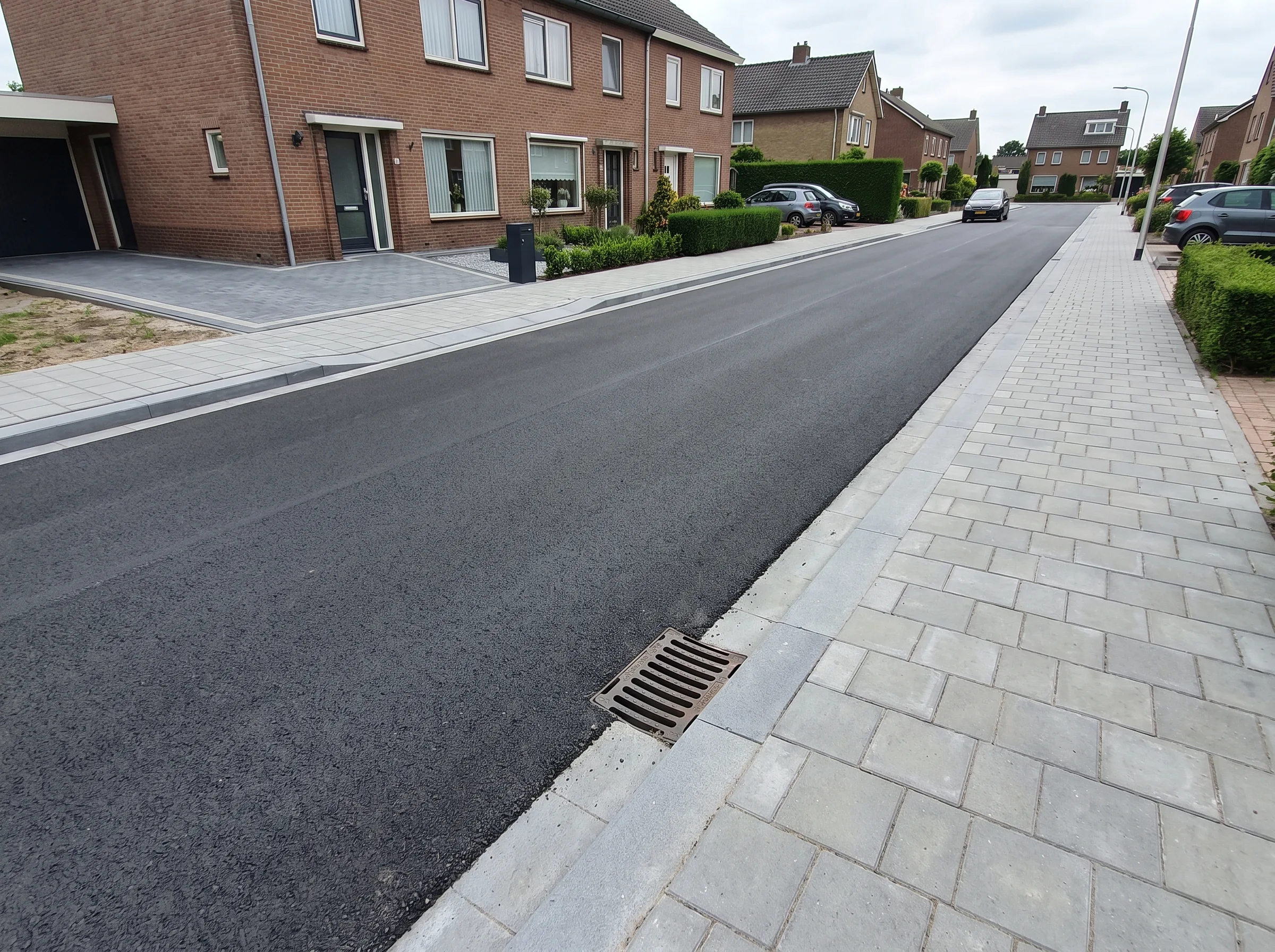 Geasfalteerde straat met klinkerkant en regenwaterafvoer